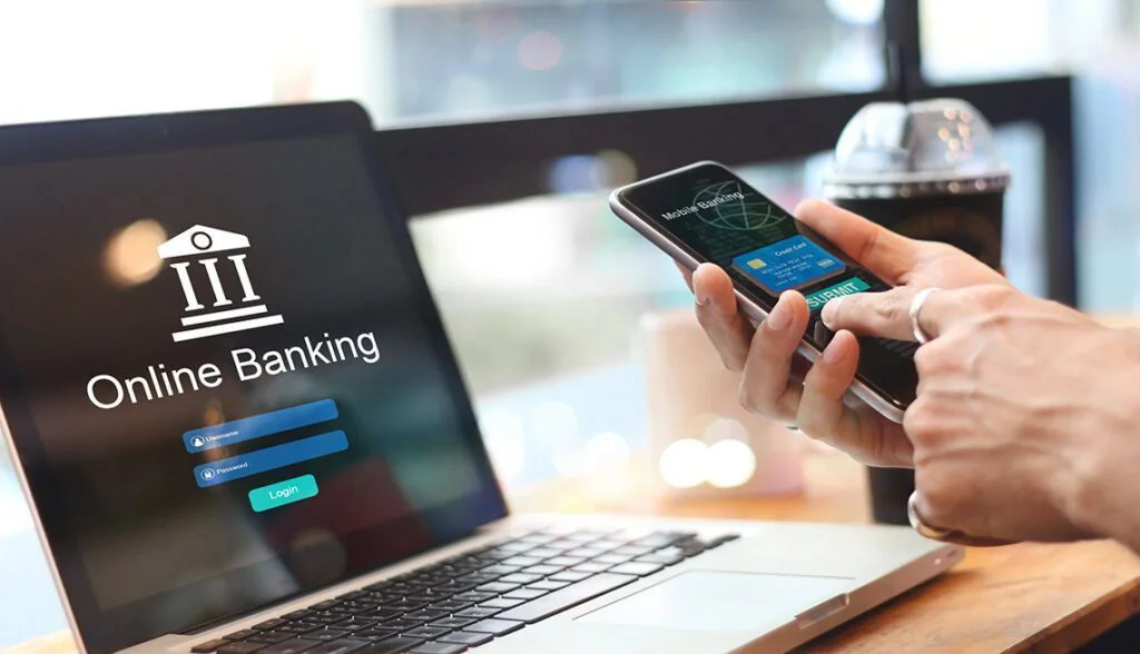 Una persona entrando al home banking desde su laptop y su teléfono celular.