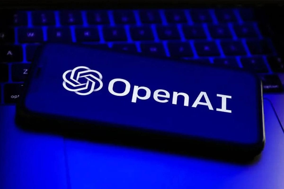 Un smartphone con el logo de OpenAI encima de una laptop