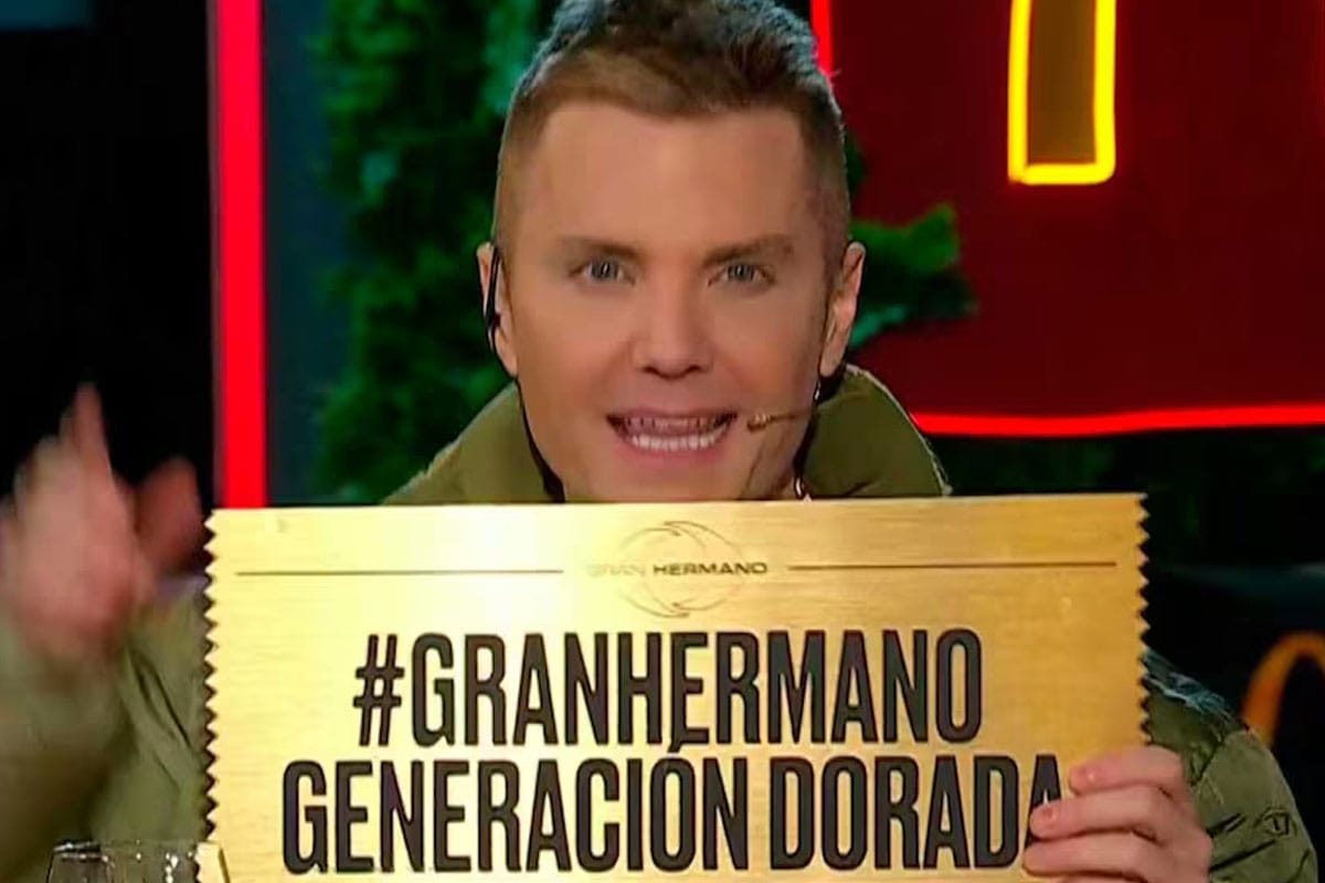 Foto de Santiago del Moro sosteniendo un cartel dorado con la leyenda "#GRANHERMANO GENERACIÓN DORADA".
